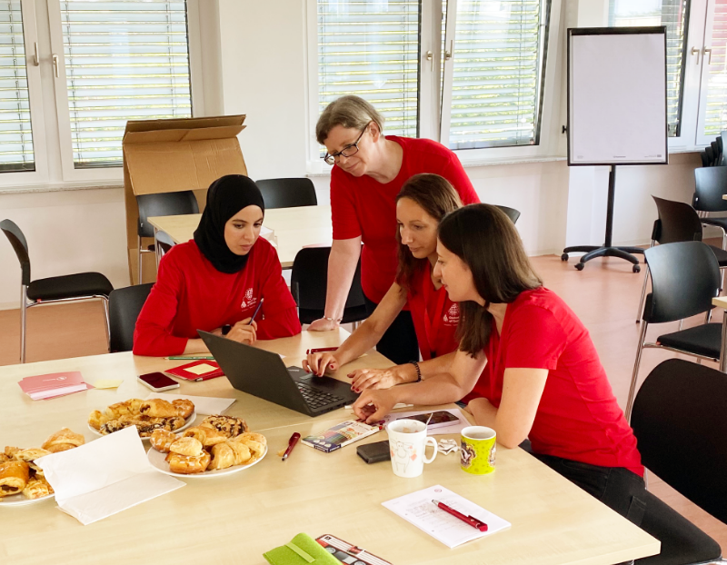 Four UL Solutions employees working together over a laptop