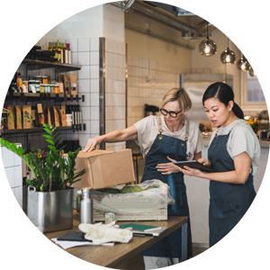 Two people inspecting produce using a tablet, inside a health food restaurant