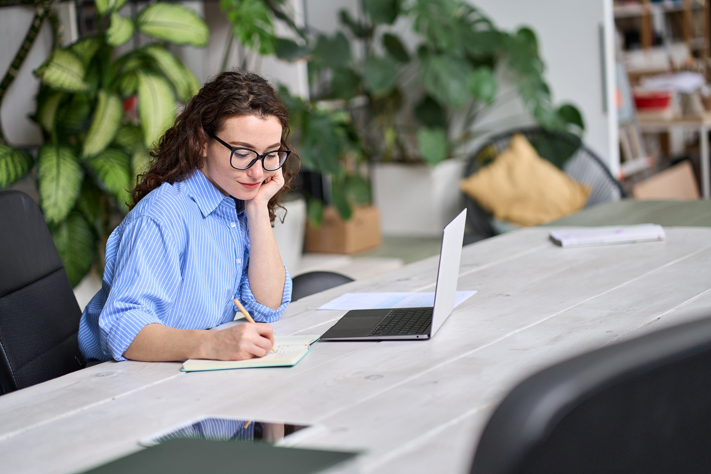 Person using laptop while taking notes