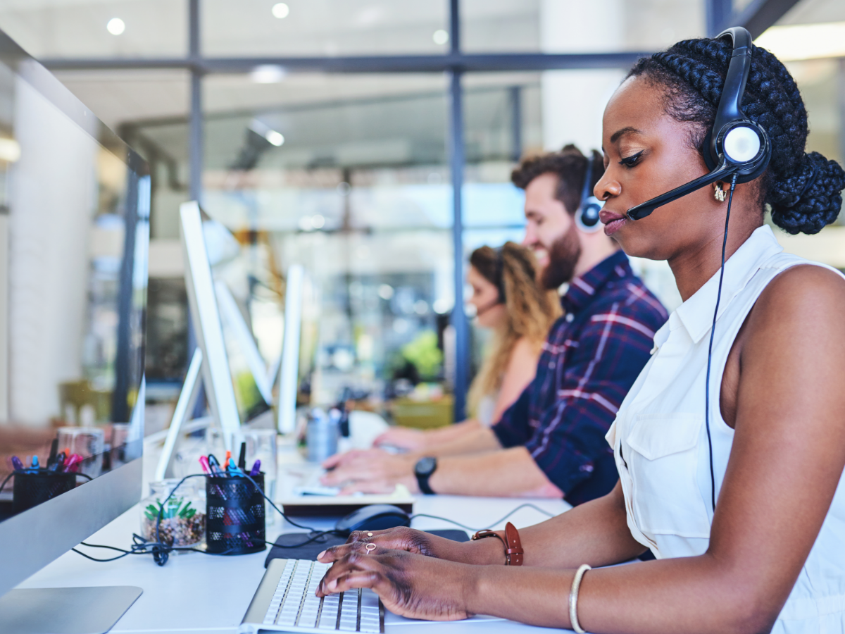 Person wearing a headset and using a computer while working in a call center
